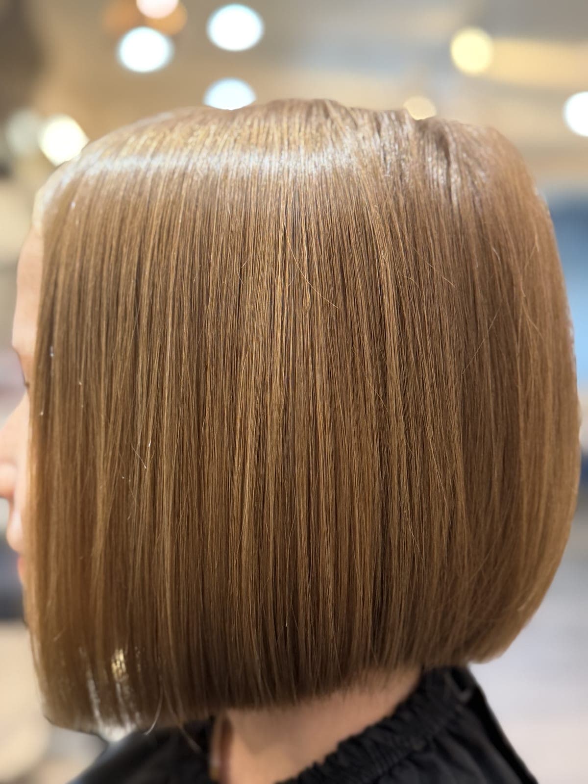 Precision one-length honey-blonde bob, perfectly sharp edge, seen from the back