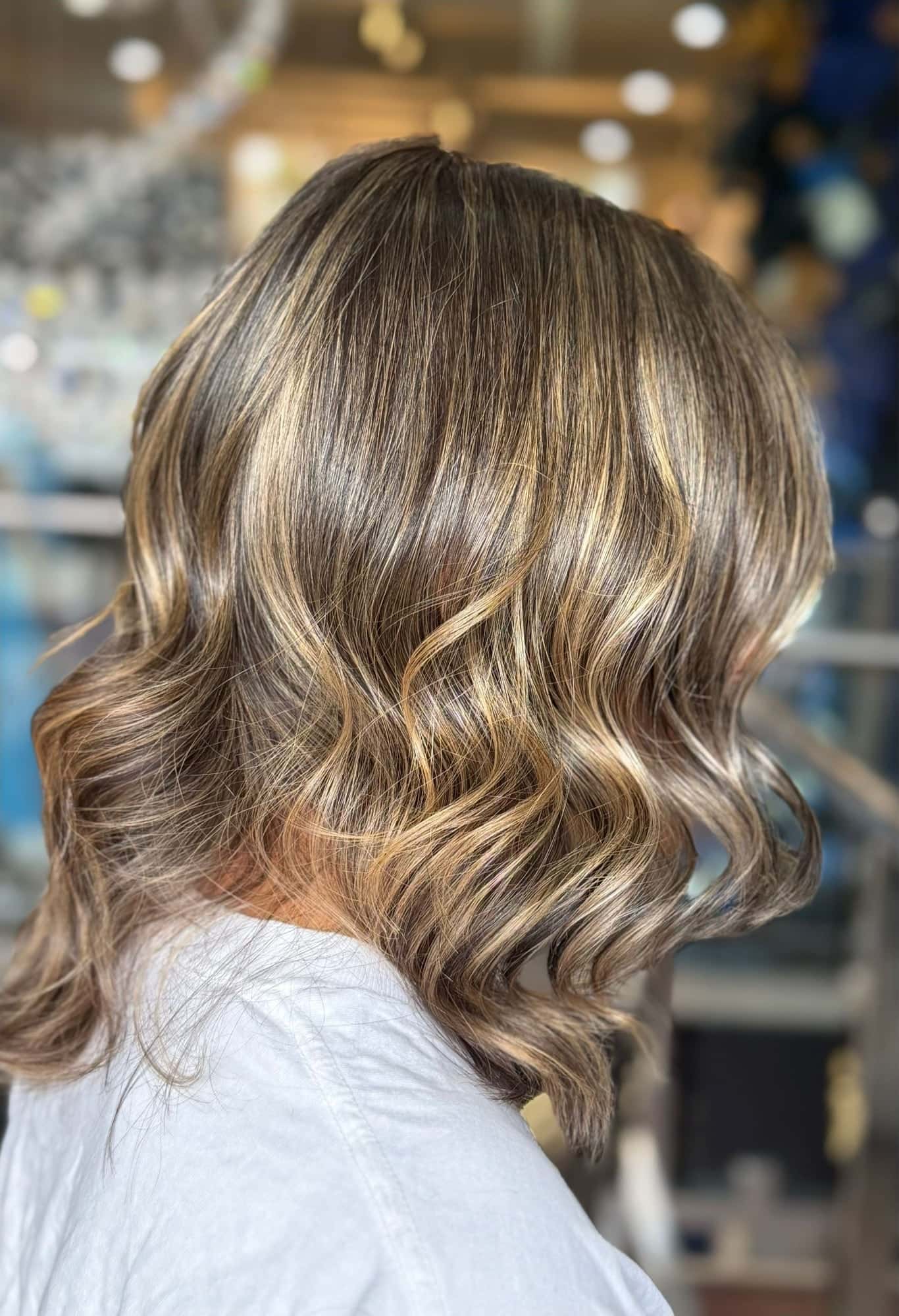 Collarbone-length bronde balayage styled in soft waves catching the light