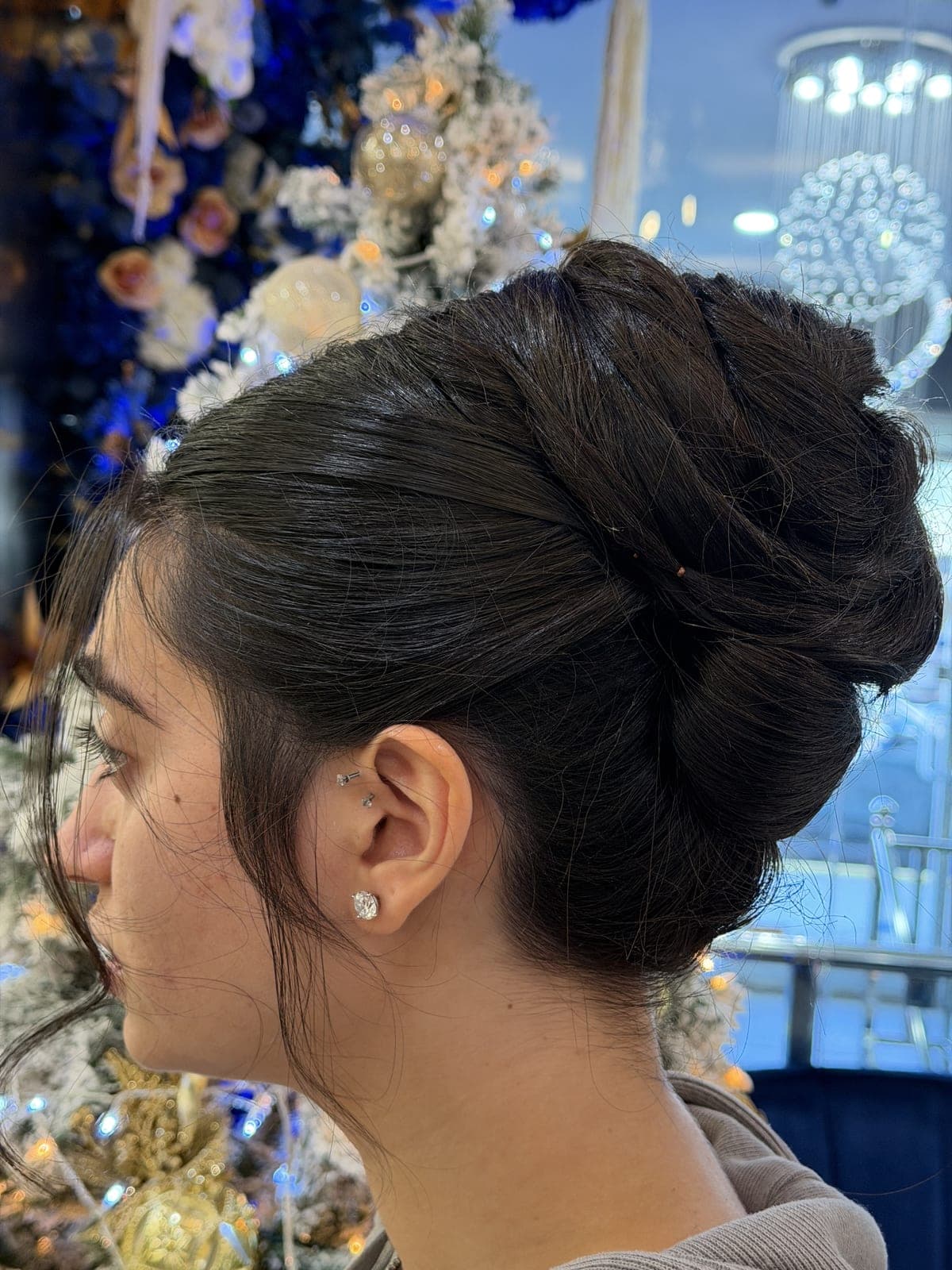 Elegant dark French-twist updo with clean sides, photographed in profile